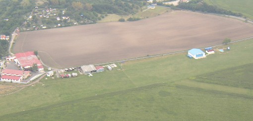 Pohled na pojížděčku. V 
levé části snímku je vidět hangár a zázemí. To malé letadélko před hangárem je Tulák Honzy Krence.